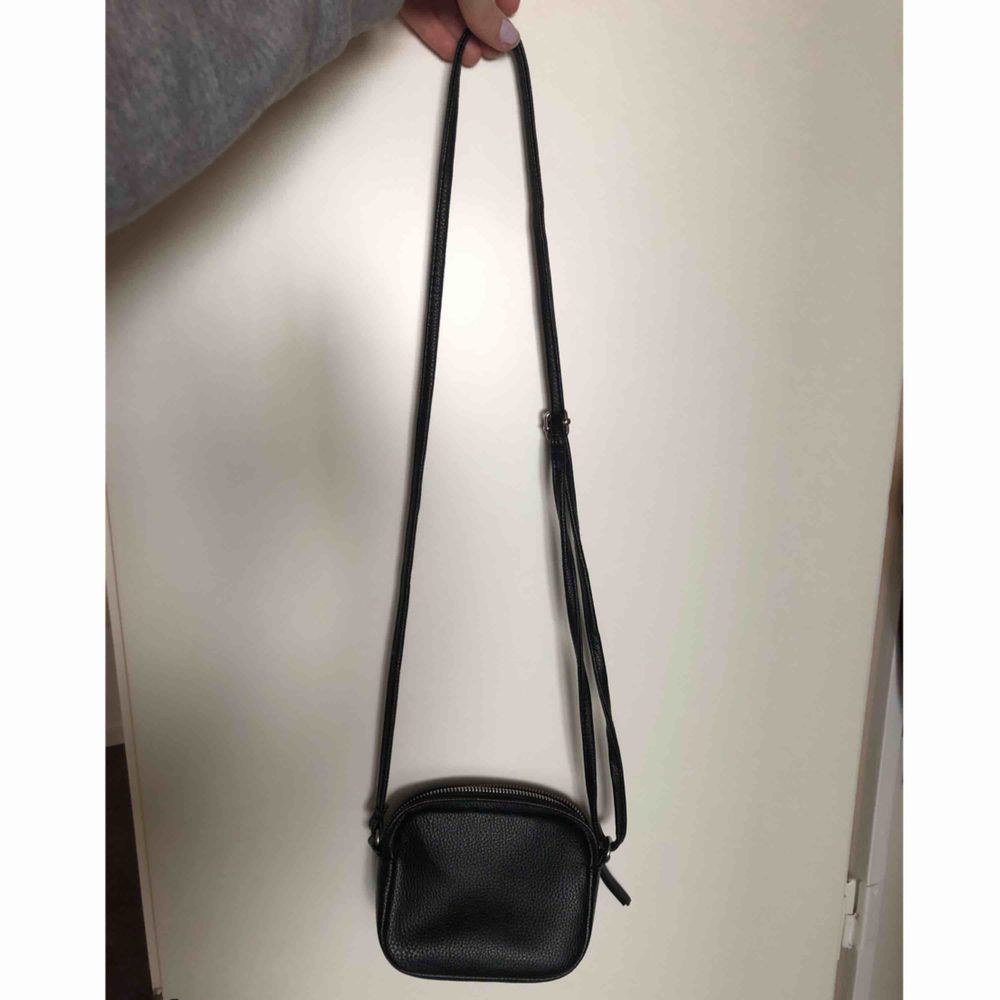 Smidig liten svart väska i fuskskinn från h&m.  Justerbart axelband. Mötas upp i sthlm eller skickar på posten, köparen betalar frakt.. Väskor.