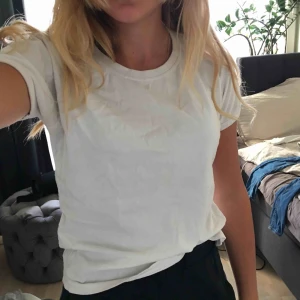  - En vanlig vit T-shirt som är ganska gammal men aldrig använd