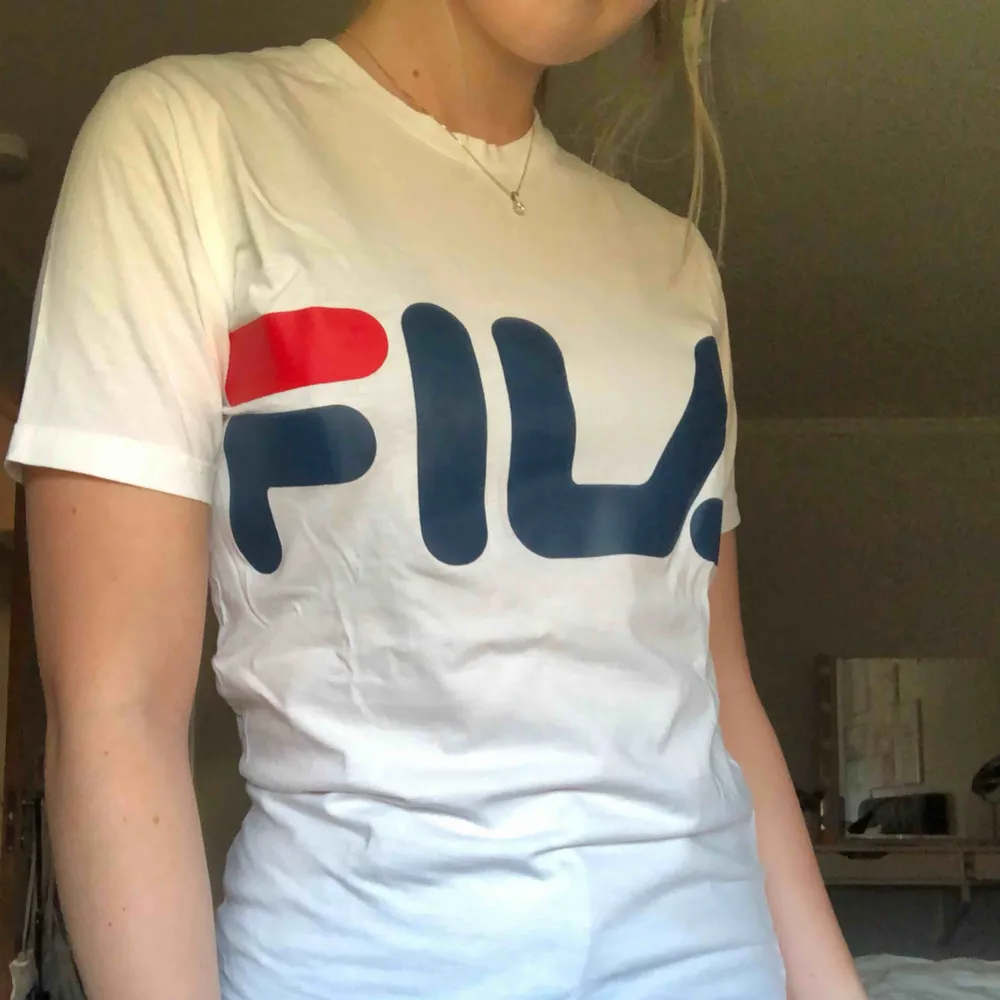 Vit Fila T-shirt i mycket bra skick. Knappt använd för det är inte riktigt min stil. Köpt för 300kr . T-shirts.