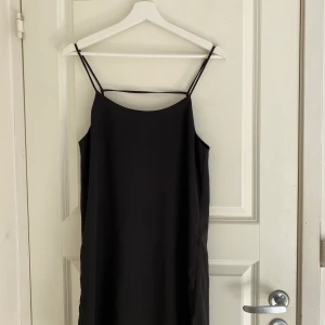 Svart klänning - Svart kortklänning med tunna band och öppenrygg.