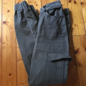 Cargobyxor från Bikbok  - Säljer dessa då jag ej använder längre. Har använt dem varsamt så skicket är super bra. De är högmidjade & har en ficka på varje sida. På bild två ser du 2 knappar, de gör så att byxan sitter tight, bra & bekvämt. De är mörkgröna 