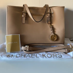 Äkta Michael kors väska  - Äkta Michael kors väska med axelrem som går att ta av och på och dustbag och en skötselbroschyr. Endast ett litet märke knappt synligt och lite avskalad guldfärg på inre dragkedjan. Startpris 550kr nypris ca 3000kr. Frakt ingår inte men kan mötas upp i Stockholm 