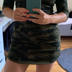 Klänning storlek 36/38 - Militärmönstrad klänning med trekvartsärm. Går ner till mitten av låret. Passar storlek 36/38. 