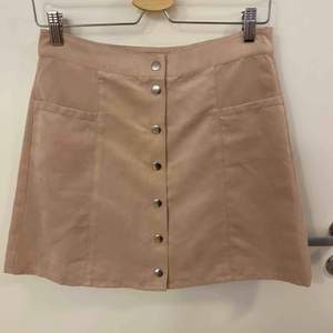 Gammalrosa kjol med knappar som öppning. Finns 2 främre fickor. Lent o mjukt tyg, använd ett fåtal gånger. 