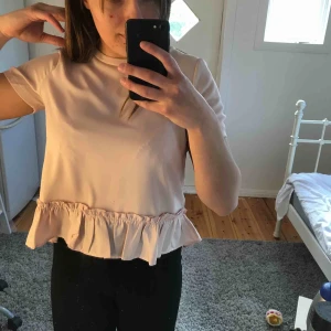  - Super söt ljusrosa T-shirt i blusmaterial med volanger. Säljer pga tycker inte jag passar i rosa och inte min stil längre.  Köparen står för frakten. 