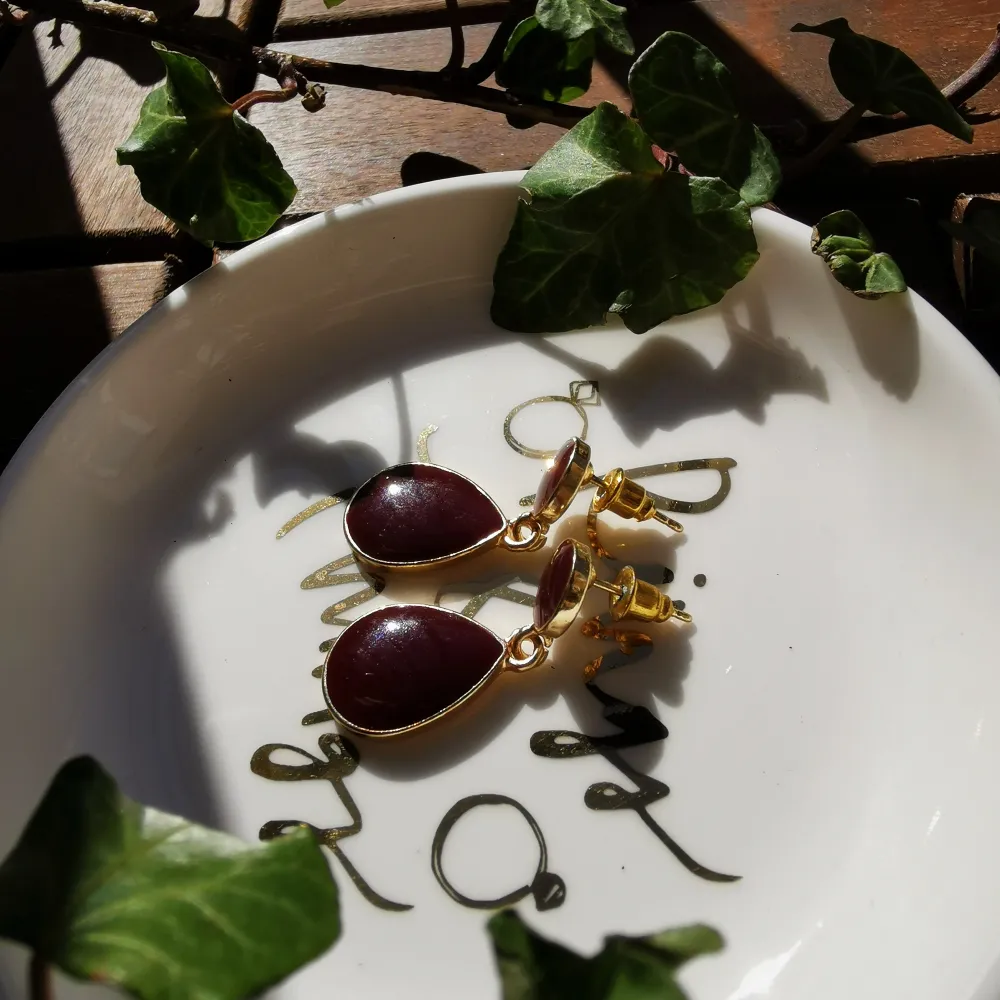 Ett par vinröda örhängen med guldiga kanter 🥀 Extra fraktkostnad tillkommer på 11 KR om de ska fraktas 📩. Accessoarer.