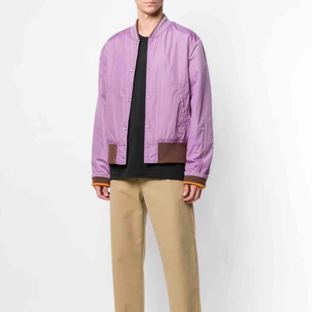 ACNE STUDIOS MILLS FACE LILAC PURPLE  Vändbar bomber/baseball-jacka från Acne Studios. Aldrig använd. Face-logga i höger nederkant ovanför mudd.   Nypris runt 3000 kr. . Jackor.