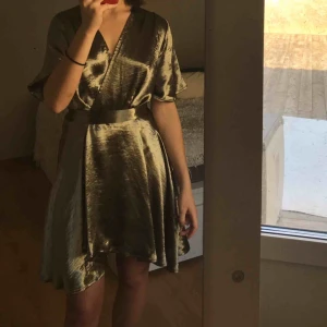  - Olive metallic wrap over dress från NA-KD. Klänningen är i superbra skick och är perfekt till sommaren! Priset är inklusive frakt 