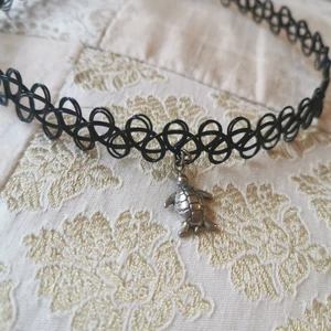 Choker med silvrig sköldpadda - Söt choker med en liten silvrig sköldpadda på. 🐢Använd endast en gång så är som ny. 30 kr plus ev frakt.