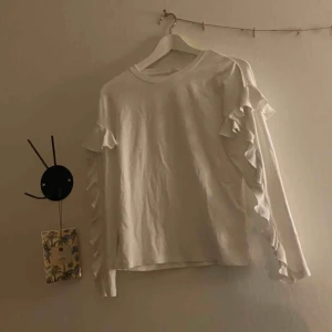  - En fin vit långärmad volang tröja från hm. Kommer ej till användning. Köparen står även för frakt:) 