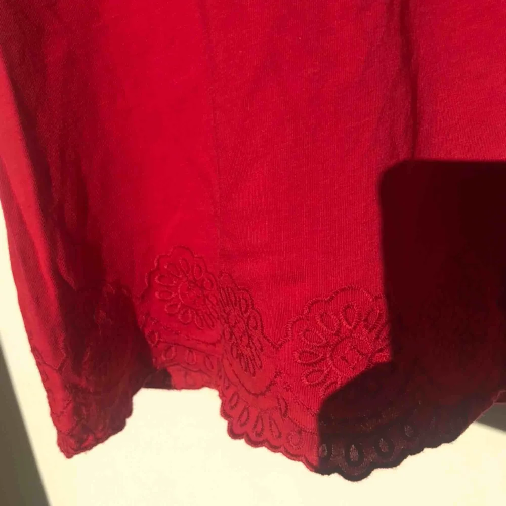 Gullig röd T-shirt, med söt spetsdetalj, köpt i Spanien. Matchas snyggt med ett färgglatt halsband eller en kedja🥰❤️. T-shirts.