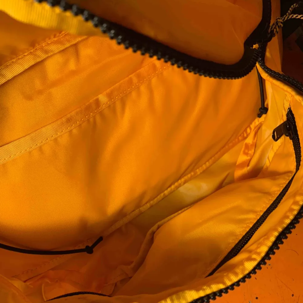 En större The North Face fannypack. Stl L, rymlig med totalt 5 fack. Fin varm gul färg med svarta detaljer. Aldrig använd, cond därav 10/10! . Väskor.