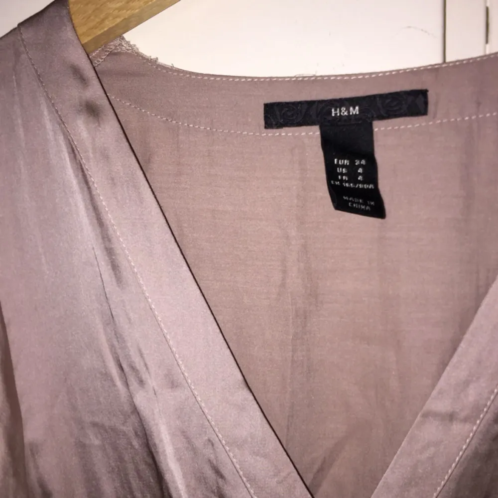 Fin klänning i silkestyg från H&M med halvlång ”puffärm”. Strl 34. Färgen är ljust gammelrosa. Klänningar.