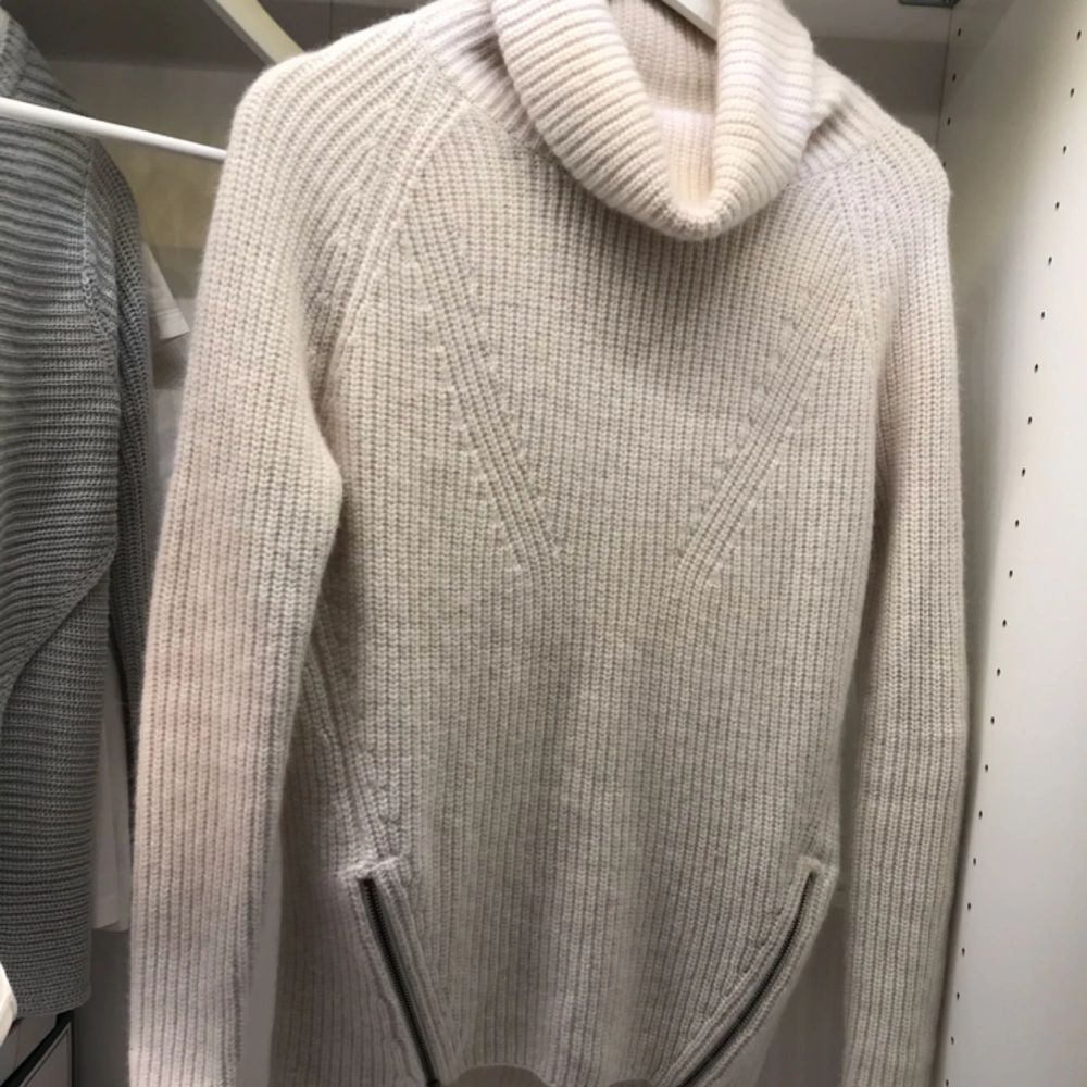 Säljer en prisvärd stickad tröja från märket Tiger of Sweden. Färgen är vit/beige skulle jag säga. Med polokrage och två snygga dragkedjor som detalj (går att öppna oh stänga). Väldigt snygg och mysig! Säljer för endast 250kr plus frakt . Stickat.