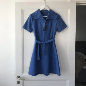  - Fantastisk vintageklänning. 70-tal. Avtagbart knytband och dragkedja fram. Fynda! Frakt är inkluderat i priset :)