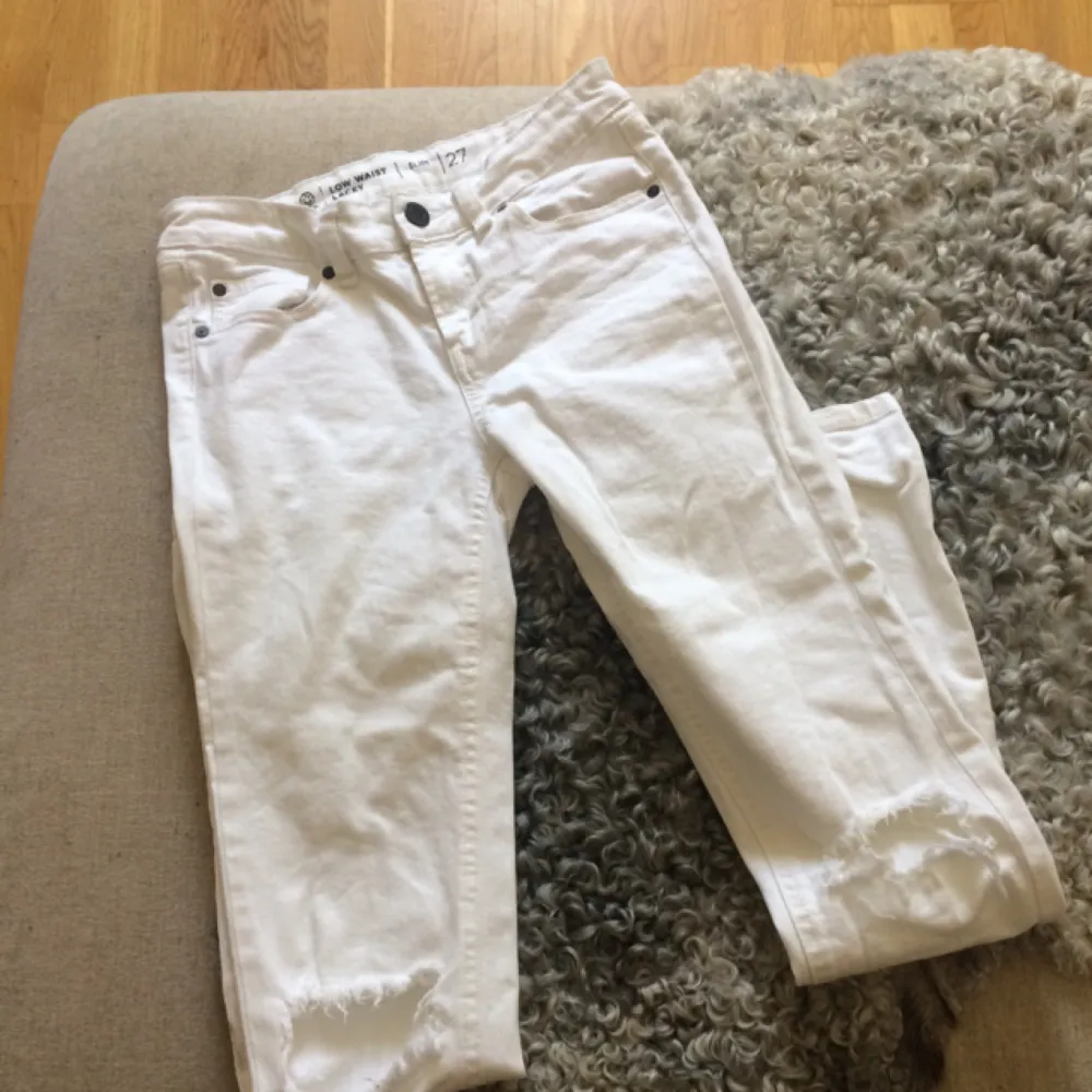 Vita jeans med låg midja och hål vid knäna. Betalning via Swish, frakt på 55:- tillkommer.. Jeans & Byxor.