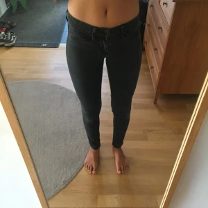  - Gråsvarta tighta jeans från Levi’s. Aningens slitna men inga hål