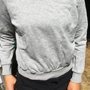  - Enkel grå sweatshirt. Melerat mjukt bomullstyg. 