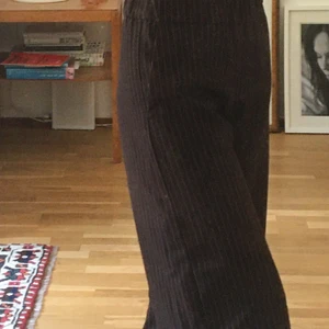 Korta svarta kostymbyxor från Monki - Korta kostymbyxor med små vita ränder på🐼🤓 De har tre mindre fläckar på ena benet ( dom syms på sista bilden),de syns dock inte när man bär byxorna. Fråga mer vid intresse🤝Köpare står för frakt😊😌