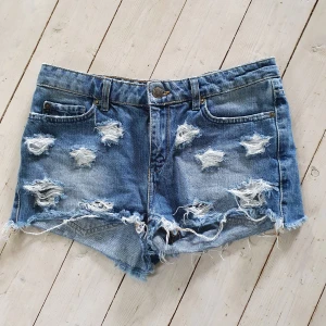 Snygga Jeansshorts 36 - Jättesnygga jeansshorts från Gina Tricot stl 36. Kortare modell med slitningar i form av stjärnor och högre midja. Mycket fint skick!