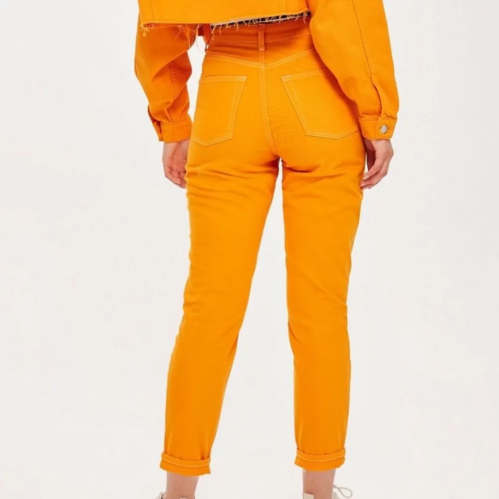 Orangea mom- jeans från topshop som är använda ett fåtal gånger! Sitter skitsnyggt men de är lite stora på mig! 26 i midja men skulle passa 27 också. 30 i längd!. Jeans & Byxor.