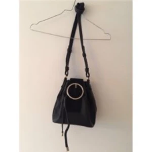  - Väska med dragsko samt spänne, vilket ger väskan en rundad form. Sparsamt använd och rymlig väska för dess storlek, 