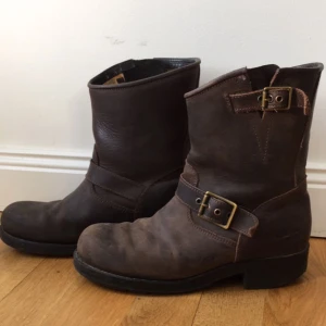  - Ett par mörkbruna låga Johnny Bulls i storlek 38 men är stora i storleken så passar en 39 också. De är väl använda, därav priset. Klacken är lite nedgången (bild 3) men det är inget man märker av. 