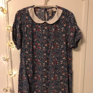  - Blommig tunn klänning med vit krage och knäppning vid nacken. Från H&M i storlek 36. Använd endast en gång. ♥️ Betalning via Swish. Möts upp i Gävle/Uppsala, annars står köparen för frakt. 