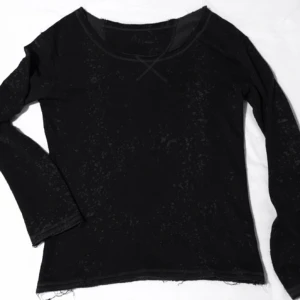  - Mörkgrå Mjuk och lite mer hängande tröja med stor hals och detaljer i form utav stänk som är i ljusare grå ton. Alla tyg ändor är "klippta" och lite fransiga. 