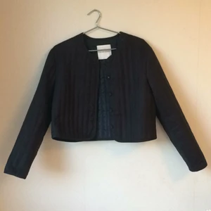  - Supersnygg och stilren kort jacka/kavaj från "PRAIRE - for weekday by Matthew Ames". Jackan är mörkblå och har "quiltat" tyg (kan skicka bättre bilder). Nederdelen av jackan slutar vid övre delen av höfterna. 