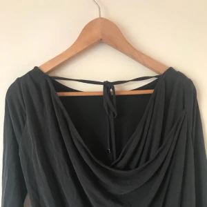  - Snygg mörkgrå tröja med draperad rygg. Storlek XS men passar även S 