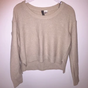  - En beige stickad tröja som är lite cropped framtill, i storlek 34 från HM. Bra skick, sparsamt använd! Köpare står för frakt 🌟