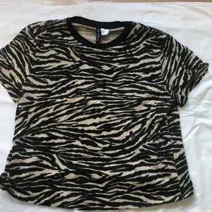 Mönstrad T-shirt i tiger-mönster. Använd några gånger men köpt för ett bra tag sedan. Kvaliteten är fortfarande god. Frakten ligger på 22 kr. 