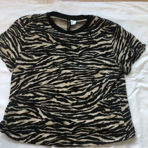 Mönstrad T-shirt!  - Mönstrad T-shirt i tiger-mönster. Använd några gånger men köpt för ett bra tag sedan. Kvaliteten är fortfarande god. Frakten ligger på 22 kr. 