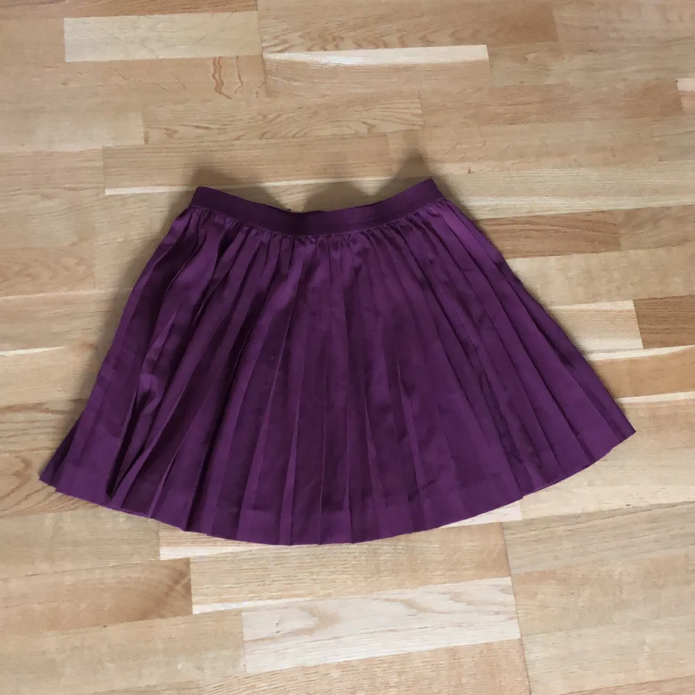 Vinröd kort, plisserad kjol från H&M stl 38. Kjolar.