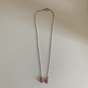 Fint halsband  - Halsband med liten rosa rosett. Kom med eget förslag ang pris. Frakt står ni för.