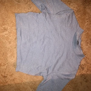 Glittrig babyblå topp från Pull&Bear - Aldrig använd endast testat, säljes eftersom den är för liten. Frakt ingår i priset 🥰