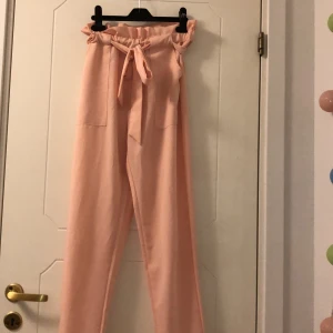 Byxor - Jättefina byxor i bra skick. Laxrosa med stora fickor fram och knyte i magen. Storlek S från Dm. Köparen står för frakt.