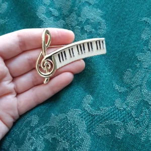 Brosch g-klav/piano - Musik-brosch säljes, 25 kr inklusive frakt eller högstbjudande! Färgen är nött, men går ju att fylla i tangenterna om en har färg som fäster. 😊