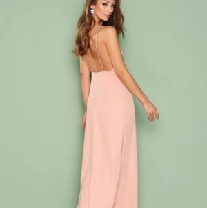 NELLY klänning - Ljusrosa långklänning från Nelly med öppen rygg och spaghettiband. Org. Pris 499 kr. Helt oanvänt (lappen sitter kvar), nyskick. Perfekt till bröllop eller bal, eller annat tillfälle. Storlek 38, jag är 175 och den är lång nog för mig att ha klackar till.