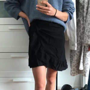 Svart volangkjol - Svart volangkjol från H&M i otroligt skönt och svalt material! Viks och knyts i midjan själv, därför kan man anpassa storlek mycket😊 säljs pga kommer inte till användning