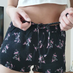 Shorts med spets - Säljer ett par sköna blommiga shorts med spets och snörning. Köpt från Pull & Bear och är i storlek xs. Kan fraktas men köparen står för frakten :)