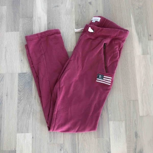  - Röda/lila/rosa mjukisbyxor från Bondelid. Modellen är rak och det finns dragkedjor på sidorna som är fickor☺️