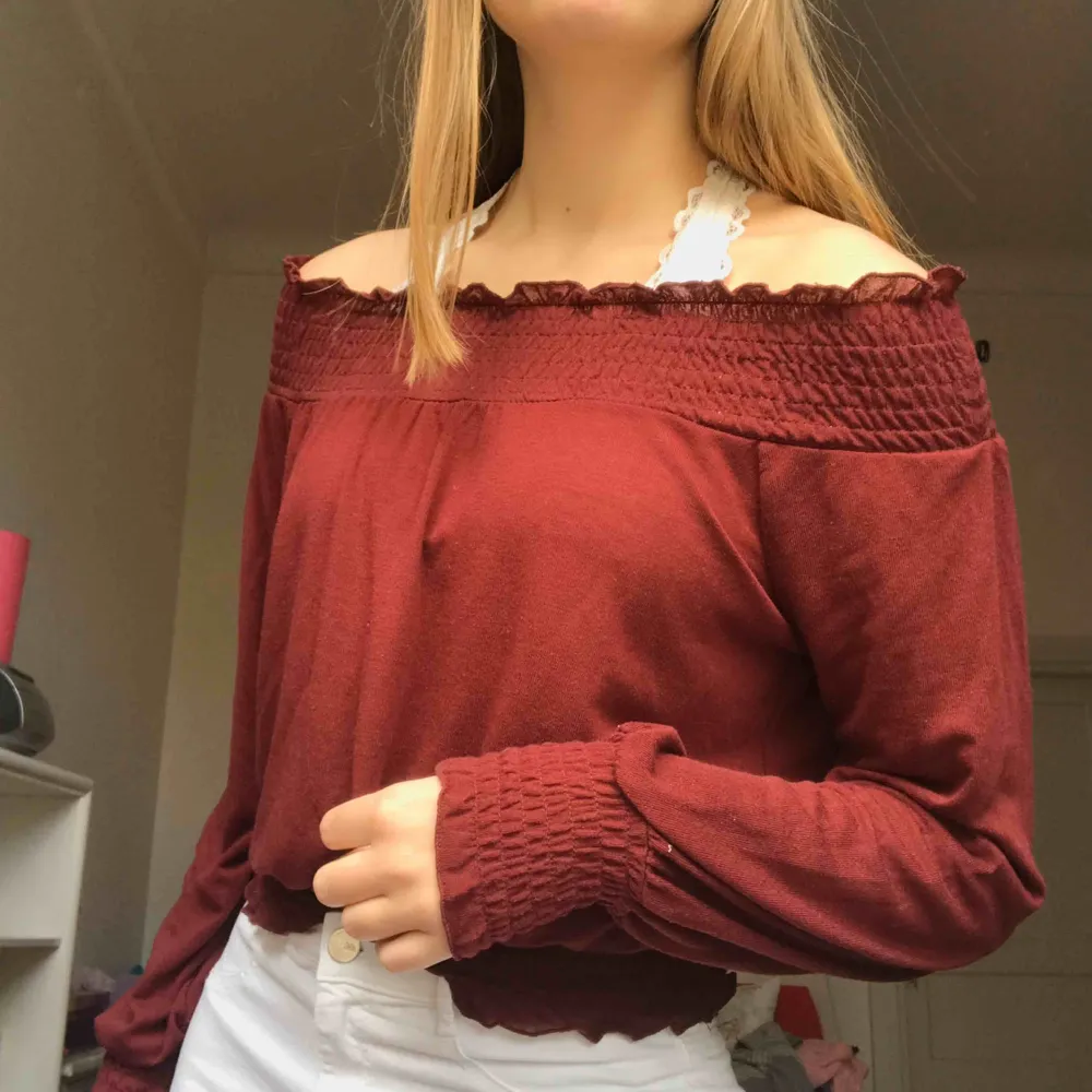 Maroon-red off the shoulder top from gina tricot. The neckline, bottom of sleeves, and bottom of the top are ruffled and the whole shirt is soft/ stretchy. It says it’s size S but could easily fit M as well💘. Toppar.