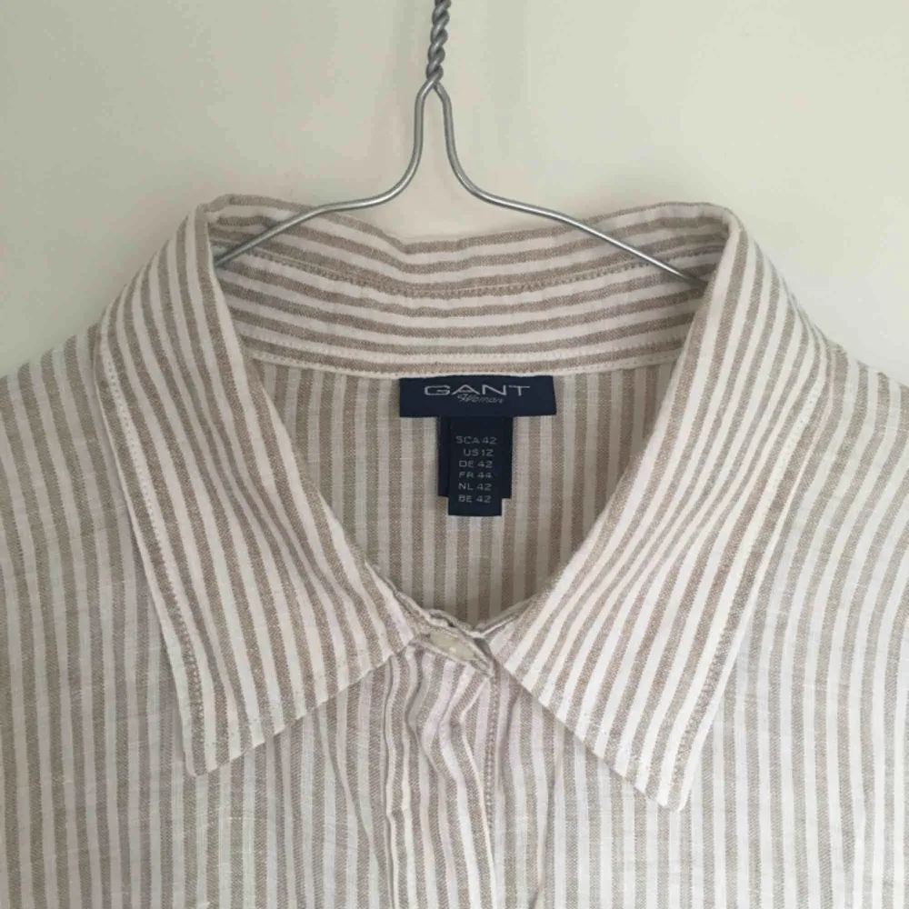 Skjorta från Gant, randig, 100% lin. Strl 42, sitter löst på mig som har storlek 38, perfekt till sommaren:)  Ev frakt betalad av köparen. Skjortor.