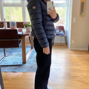 Colmar marinblå dunjacka  - En marinblå colmar jacka, vinter/höst jacka. Använd under en vinter. Den är i bra skick. Inga hål eller liknande. Dock sminkfläkar längst kragen! Ny pris ca 3500kr det är en utländsk storlek (44) men svensk storlek är isch 38 