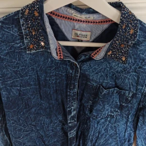 Tommy Hilfiger tunn jeansskjorta - Tunn jeansskjorta med pärldekoration på krage. Använd 1 gång.