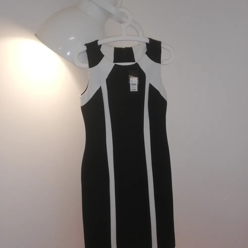 New Knee-length black dress with geometric white cream line details. Falls just under the knee. Workwear. . Klänningar.