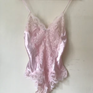 Body i siden!  - Jättefin body i siden med spets och djup rygg! Den är köpt second hand men jag har aldrig använt den då den är några storlekar för stor. Skicket är verkligen fantastiskt och den ser ut som ny! Frakt ingår i priset! 