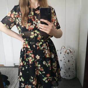 Monki sommarklänning  - En klänning jag alltid tyckt om för att den är så vacker. Den är genomskinlig och har knappar på överdelen. Den har också ett band man knyter i midjan och en svart underkjol. blomtyget är meshtyg. Köparen står för frakt. 